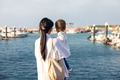 Young mum embracing baby looking at ocean view - PhotoDune Item for Sale
