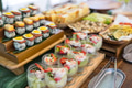 Fresh sushi and appetizer buffet on wooden table - PhotoDune Item for Sale