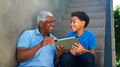 Grandfather With Grandson Sitting On Steps Outdoors At Home Using Digital Tablet - PhotoDune Item for Sale