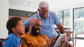Multi-Generation Male African American Family Sitting On Sofa At Home Using Digital Tablet - PhotoDune Item for Sale