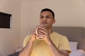 Young man enjoying morning coffee at home, looking thoughtful and relaxed - PhotoDune Item for Sale