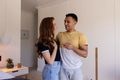 Young couple laughing and talking together at home in cozy living room - PhotoDune Item for Sale