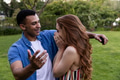Young couple laughing and embracing in park, enjoying joyful moment together - PhotoDune Item for Sale
