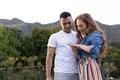 Admiring engagement ring, couple outdoors with joyful expressions and happiness - PhotoDune Item for Sale