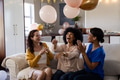 Women laughing and celebrating with balloons at home, enjoying festive atmosphere - PhotoDune Item for Sale