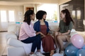 Women sitting on couch, chatting and celebrating with balloons at home - PhotoDune Item for Sale