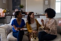 Women enjoying conversation and snacks on sofa during festive home gathering - PhotoDune Item for Sale