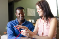 Couple exchanging gift at home, smiling and enjoying special moment together - PhotoDune Item for Sale