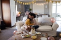 Friends hugging on sofa at home during birthday celebration with cake and snacks - PhotoDune Item for Sale