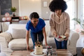 Women preparing birthday celebration with cake and fruit bowl in living room - PhotoDune Item for Sale