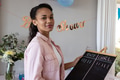 Smiling woman holding chalkboard at baby shower, enjoying festive celebration - PhotoDune Item for Sale