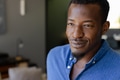 Smiling man in blue shirt enjoying relaxed moment at home - PhotoDune Item for Sale