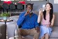 Couple enjoying drinks together on sofa, celebrating at home with champagne - PhotoDune Item for Sale