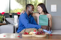 Couple exchanging gifts and laughing together on cozy living room couch - PhotoDune Item for Sale