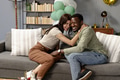 Couple celebrating at home, sitting on sofa and embracing with joy - PhotoDune Item for Sale