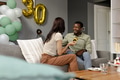 Celebrating 30th birthday, couple having cake and chatting on cozy living room sofa - PhotoDune Item for Sale