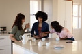 Friends celebrating pregnancy in kitchen, smiling and enjoying tea together - PhotoDune Item for Sale