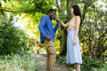 Couple enjoying romantic moment in lush garden, smiling and holding hands - PhotoDune Item for Sale