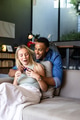 Couple at home, man surprising woman with gift, both smiling and joyful - PhotoDune Item for Sale