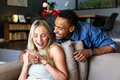 Couple at home laughing together while looking at smartphone on couch - PhotoDune Item for Sale