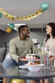 Smiling couple celebrating birthday with cake and decorations at home - PhotoDune Item for Sale