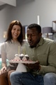 Blowing candles on cake, African American man celebrating birthday with woman - PhotoDune Item for Sale