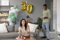 Celebrating 30th birthday, woman cutting cake while man bringing plates at home - PhotoDune Item for Sale