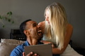 Couple laughing together while using tablet at home, enjoying relaxed moment - PhotoDune Item for Sale