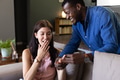 Man proposing to surprised woman at home, both smiling and joyful - PhotoDune Item for Sale