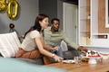 Celebrating birthday, diverse couple enjoying cake together in cozy living room - PhotoDune Item for Sale