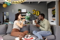 Friends enjoying cake and celebrating birthday at home with festive decorations - PhotoDune Item for Sale