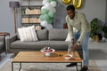 Man preparing snacks and drinks on coffee table for home celebration party - PhotoDune Item for Sale