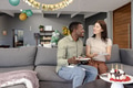 Celebrating birthday, African American man and woman enjoying cake on sofa at home - PhotoDune Item for Sale