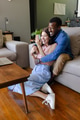 Couple sitting on floor, smiling and waving during video call at home - PhotoDune Item for Sale