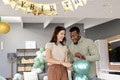 Couple decorating living room with balloons, preparing for birthday celebration - PhotoDune Item for Sale