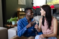 Couple toasting with champagne glasses, smiling and celebrating at home together - PhotoDune Item for Sale