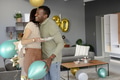 Friends hugging and celebrating birthday with balloons and cake at home - PhotoDune Item for Sale
