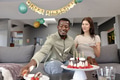 Celebrating birthday, friends enjoying cake and smiling in cozy living room - PhotoDune Item for Sale