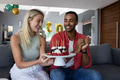 Happy couple celebrating birthday at home with cake and candles, smiling joyfully - PhotoDune Item for Sale