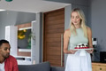Woman carrying cake stand with cupcakes, preparing for celebration at home - PhotoDune Item for Sale