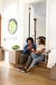 Young diverse couple sitting on steps, enjoying coffee and conversation in new home - PhotoDune Item for Sale