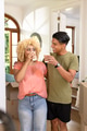 Young diverse couple enjoying coffee break while unpacking boxes in new home - PhotoDune Item for Sale