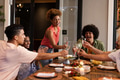 Diverse friends celebrating with toast at outdoor dinner party, enjoying joyful moments - PhotoDune Item for Sale