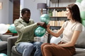 Friends playing with balloons and laughing together in cozy living room - PhotoDune Item for Sale