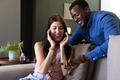Happy couple exchanging gifts on cozy sofa, sharing joyful surprise and laughter - PhotoDune Item for Sale