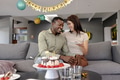 Couple celebrating birthday at home, enjoying cake and sharing joyful moment - PhotoDune Item for Sale