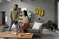 Celebrating 30th birthday, friends enjoying cake and snacks in modern living room - PhotoDune Item for Sale
