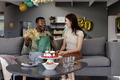 Man opening gift while woman smiling on couch during birthday celebration at home - PhotoDune Item for Sale