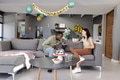 Friends laughing and enjoying birthday cake in modern living room celebration - PhotoDune Item for Sale