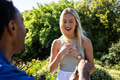 Man proposing to surprised woman in garden, both smiling with joy - PhotoDune Item for Sale